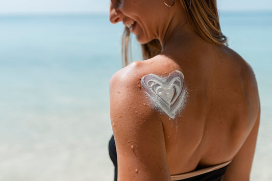 Mujer aplicando protector solar mineral para proteger la piel sensible frente a los rayos UVA y UVB y prevenir el envejecimiento de la piel.